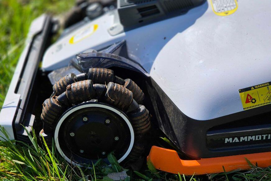 Nahaufnahme des Profilreifens am Mammotion LUBA 3 AWD Mähroboter. Robuste Gummireifen für maximale Traktion an Hängen und auf unebenem Terrain.